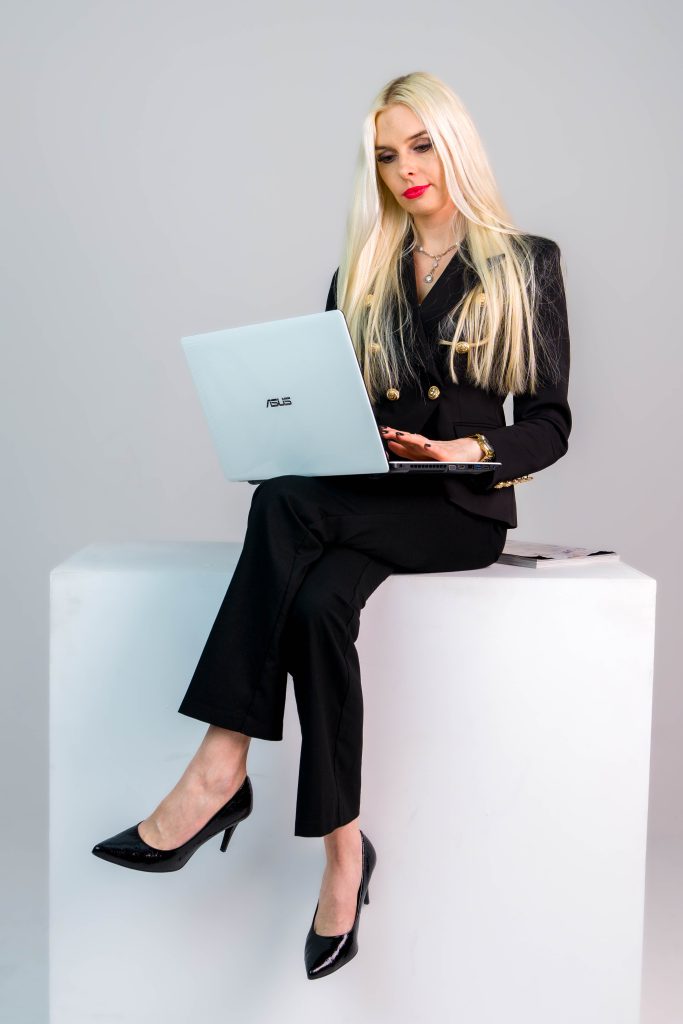 Fotografia portretowa - biznesowa Poznań z modelką z długimi blond włosami siedzącą
