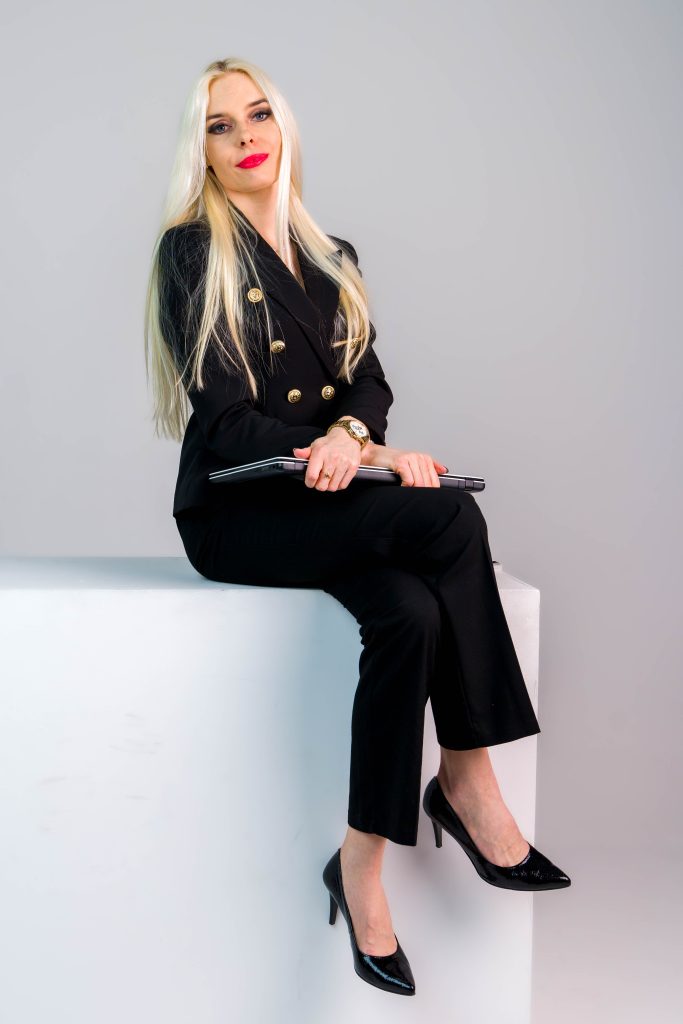 Sesja biznesowa studyjna Poznań z modelką z długimi blond włosami siedzącą