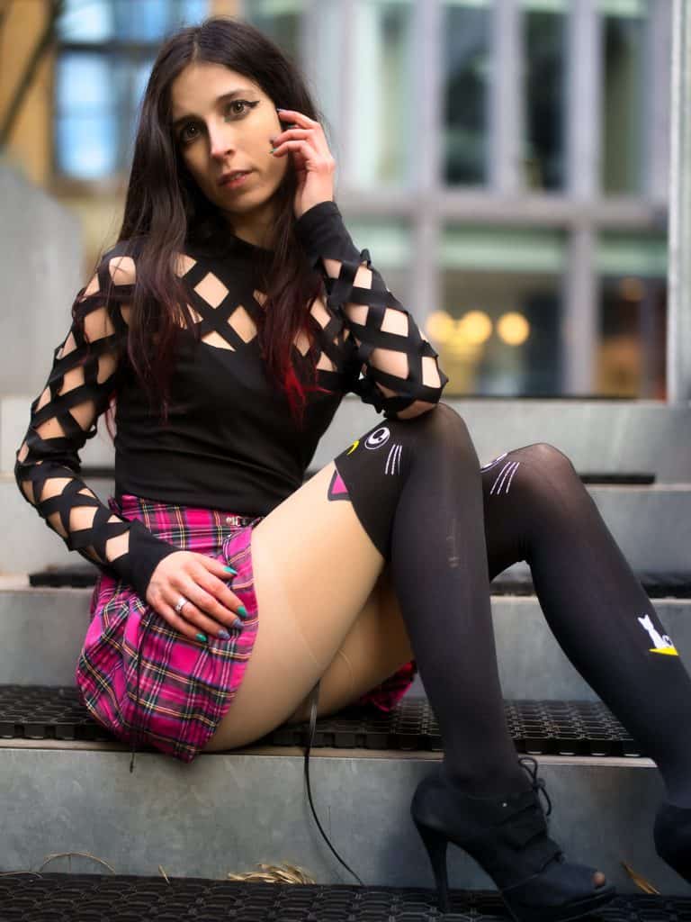 Fotografia portretowa - biznesowa w Poznaniu z modelką siedząca na schodach w krótkiej spodniczce